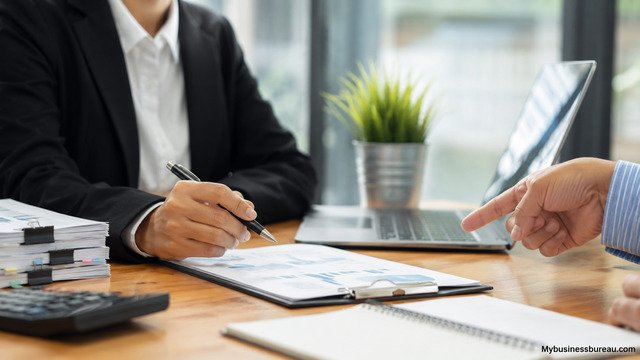 Business professionals reviewing financial approval documents in office
